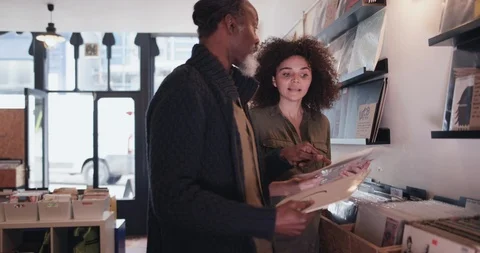 Store owner helping customer in a record store Stock Footage 87534339