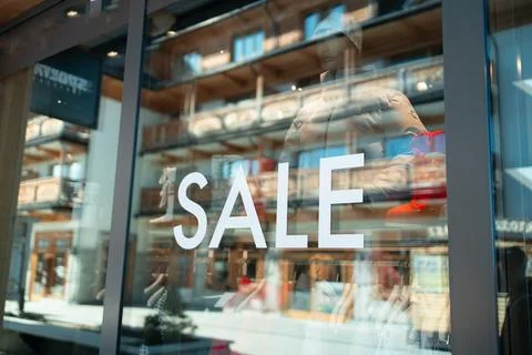 Store storefront window with large white sale sign text on glass Fotos de archivo