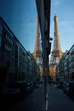 A store window in Paris reflects the Eiffel Tower at sunrise. Stock Photos