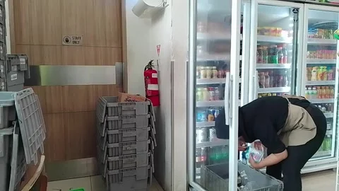 Store worker restocking and arranging beverages in refrigerator Vídeo Stock 336487545