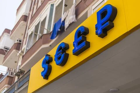 A storefront dedicated to currency exchange features vibrant blue and yellow  Stock Photos