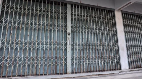Storefront with locked metal gate in a quiet street Stock Footage 337183190