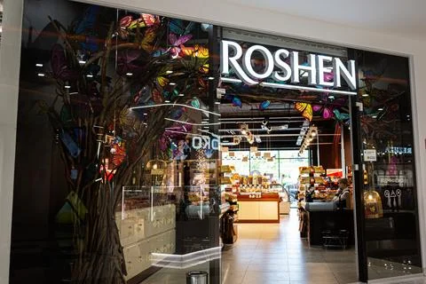 Storefront Roshen with decorative elements and illuminated signage displayi.. Stock Photos
