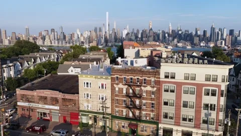 Storefront sign marks brick corner building beneath colorful apartment facades Stock Footage 340971009