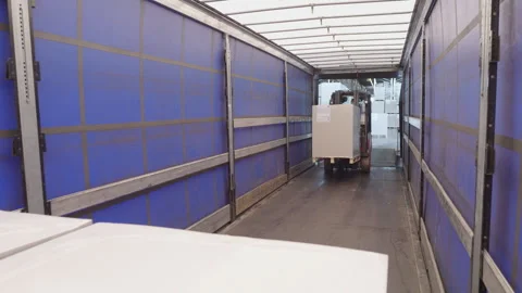 Storehouse forklift loading cargo in shipping container, view from storage Stock Footage 248647750