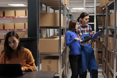 Storehouse managers comparing orders checklist on clipboard and tablet Foto stock