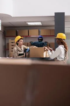 Storehouse workers using box sealing tape for packing parcel Stock Photos