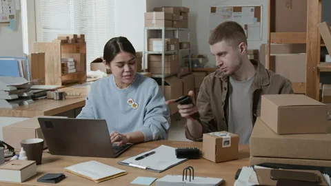 Storeroom Manager Scanning Barcodes on Parcels and Communicating with Colleague Stockbeeldmateriaal 306286495