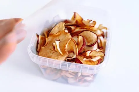 Storing apple chips in an eco-plastic box Stock Photos
