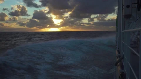 Storm and sun at sea. Rays of sun through clouds. Splashes from bow of vessel Stock Footage 262228208