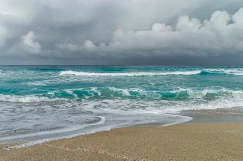 Storm on the Atlantic coast, beach patch, waves, foam, low clouds over the oc Stock Photos