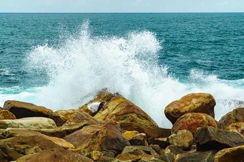 Storm on the beach. Big waves break against the rocks Stock Photos