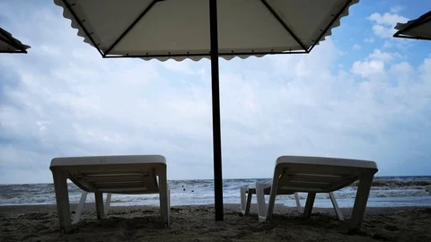 Storm on the beach. Empty sun beds as a concept of nature riot Stock Footage 112164245