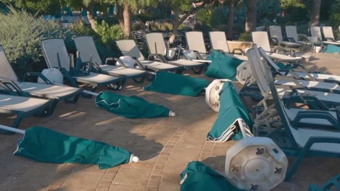 Before a storm, beach umbrellas are folded and put down on the tiles Stock Footage 323855995