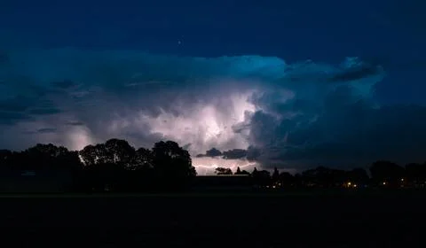 Storm cloud is illuminated by lightning flashes Stock Photos