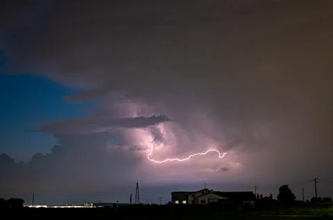 Storm cloud with lightning at dusk in the Po Valley, northern Italy Stock Photos