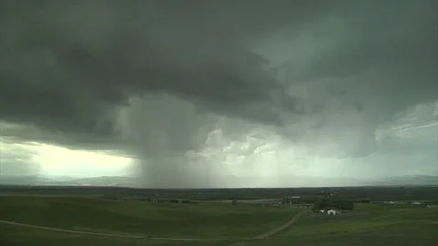 Storm cloud moving across plush green landscape Stock Footage 74095832