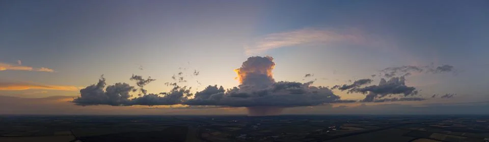 Storm cloud with rain at sunset Stock Photos