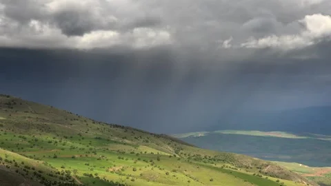 Storm clouds above green hills rain curtains shifting weather - Hillside Meadow Stockbeeldmateriaal 339567035