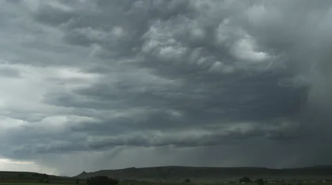Storm clouds advancing with lightning and rain across prairie hills Stock Footage 59513985