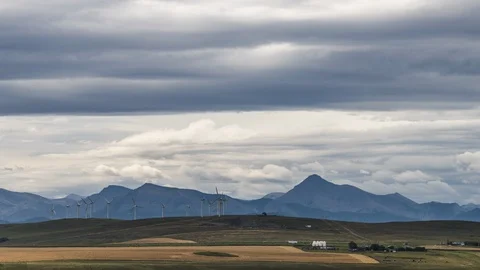 Storm clouds and mountains behind wind turbines 8K timelapse Video stock 117948551