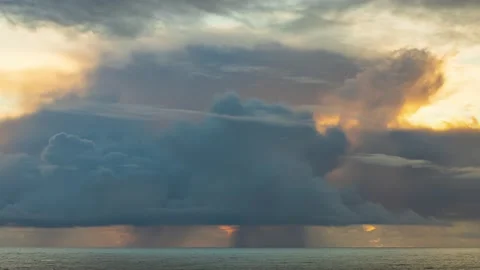 Storm clouds and rain in the distance at sunset causing yellow sky - timelapse Vídeos de archivo 220018025