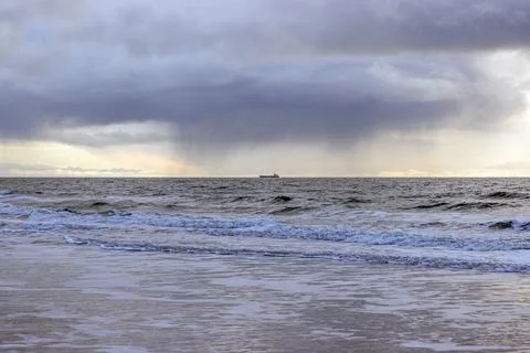 Storm clouds and rain over sea horizon with distant cargo ship Foto stock