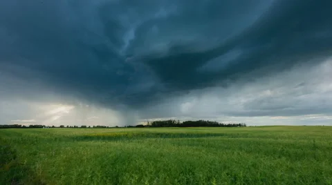 Storm clouds and sunbeams rolling over a prairie field Stock Footage 68959660