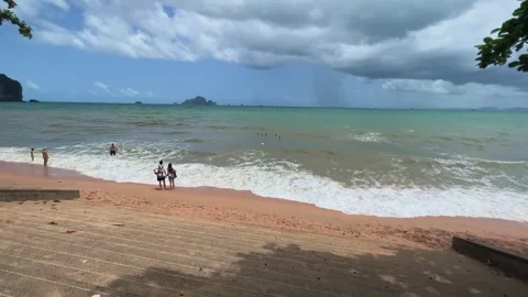 Storm Clouds Approaching Tropical Beach in Krabi Thailand With Tourists Stockbeeldmateriaal 345294596