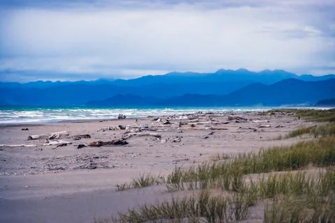 Storm clouds at the beach with mountains in the distance Stockfoto's