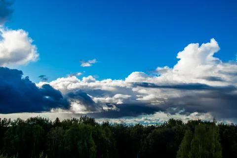 Storm clouds on a blue sky. Dramatic landscape. Background for design. Stock Photos