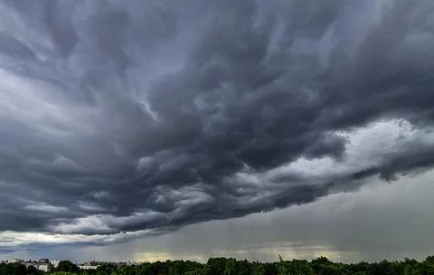 Storm clouds. Dramatic sky over city. Thunderstorm weather. Rain pours from c Stock Photos