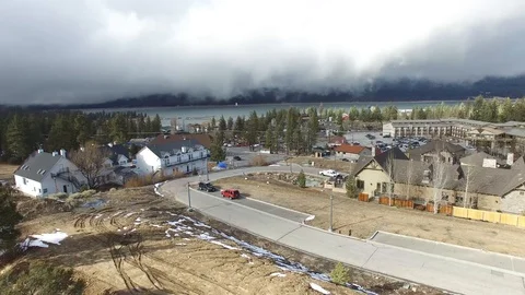 Storm clouds drift over lake town Stock Footage 86889581