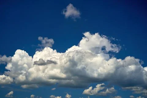Storm clouds float across the blue sky Stock Photos