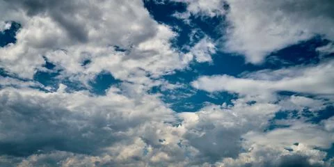 Storm clouds float across the blue sky Stock Photos