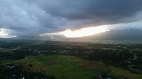 Storm clouds gather above terraced fields with scattered houses Vídeos de archivo 334055102