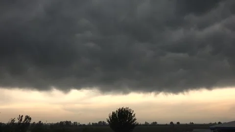 Storm clouds gather over flat grassland at dawn - Open Field and Wide Landscape Stock Footage 339644098