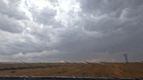 Storm clouds gather over open countryside in side window view Stock Footage 343805240