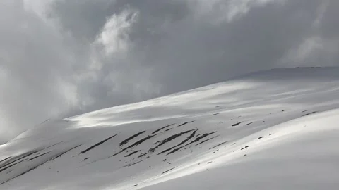Storm clouds gather over a snowy mountain slope in the French Pyrenees Stock Footage 339354955