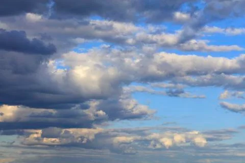 Storm clouds gather in the sky in the rays of the setting sun. Stock Photos