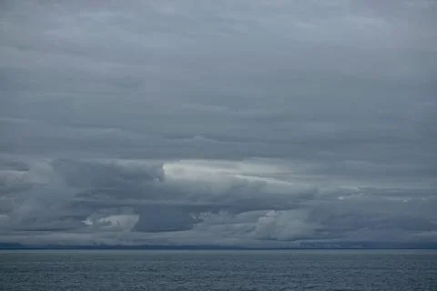 Storm clouds gathering over the deep blue waters of the Gulf of Alaska. Stock Photos