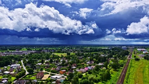 Storm clouds gathering over a small town with dramatic sky and railroad track Vídeos de archivo 337387845