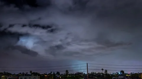 Storm clouds lightning strike bolt over night city of Los Angeles cityscape. 4K Stock Footage