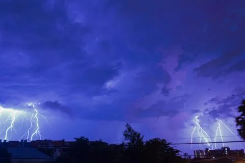 Storm clouds with lightning strike bolts passing over night city of Bangkok c Foto stock