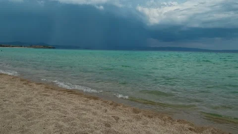 Storm clouds loom above turquoise waters. Trani Ammouda, Greece Stock Footage 339619754