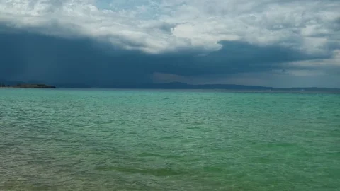 Storm clouds loom over turquoise sea. Trani Ammouda, Greece Stock Footage 339619475