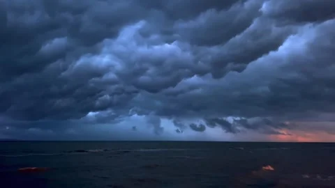 Storm clouds moving over dark ocean at sunset in time lapse Stock Footage 341327750