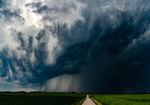 Storm clouds over field, tornadic supercell, extreme weather, dangerous storm Stock Photos