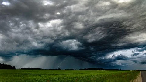 Storm clouds over field, tornadic supercell, extreme weather, dangerous storm Stock Photos
