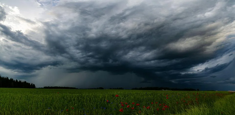 Storm clouds over field, tornadic supercell, extreme weather, dangerous storm Stock Photos